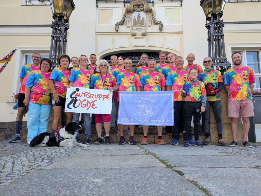 Laufgruppe Lügde macht ein Gruppfoto vor einer alten Hausfassade.