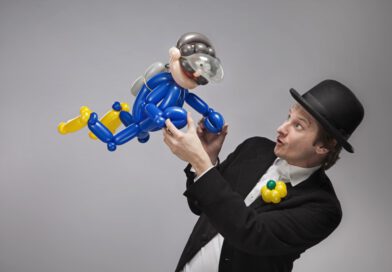Tobi van Deisner, in formalem Anzug und Hut, mit einem Spielzeug-Taucher in den Händen.