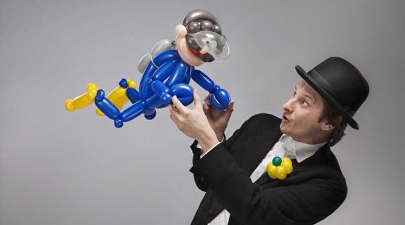 Tobi van Deisner, in formalem Anzug und Hut, mit einem Spielzeug-Taucher in den Händen.
